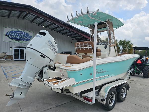 Slide: The Image of 2025 Pioneer 202 Islander boat with Suzuki engine on a trailer, parked outside a dealership. - 3