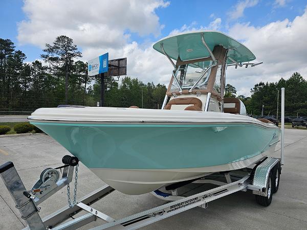 Slide: The Image of 2025 Pioneer 202 Islander boat on trailer, light blue hull, parked outdoors. - 5