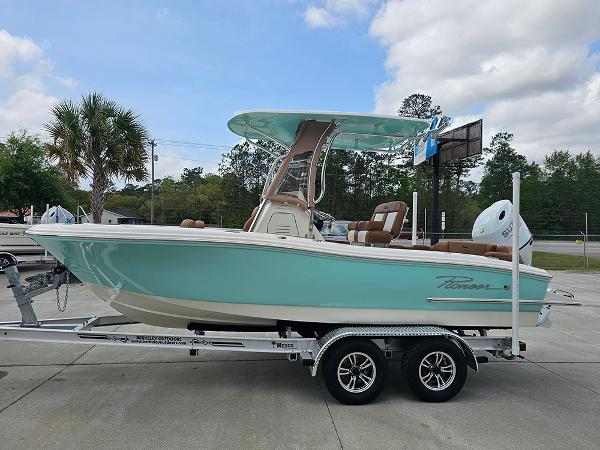 Slide: The Image of 2025 Pioneer 202 Islander boat on trailer, turquoise hull, parked outdoors. - 6