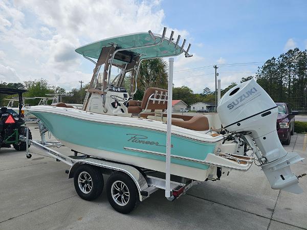 Slide: The Image of 2025 Pioneer 202 Islander boat on trailer with Suzuki outboard motor, parked outdoors. - 7