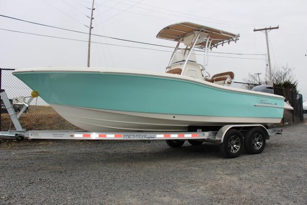 Slide: The Image of 2022 Pioneer 220 Bay Sport boat on trailer, light blue hull, parked outdoors. - 0