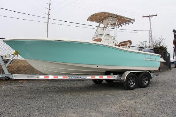 Slide: The Image of 2022 Pioneer 220 Bay Sport boat on trailer, light blue hull, parked outdoors. - 1