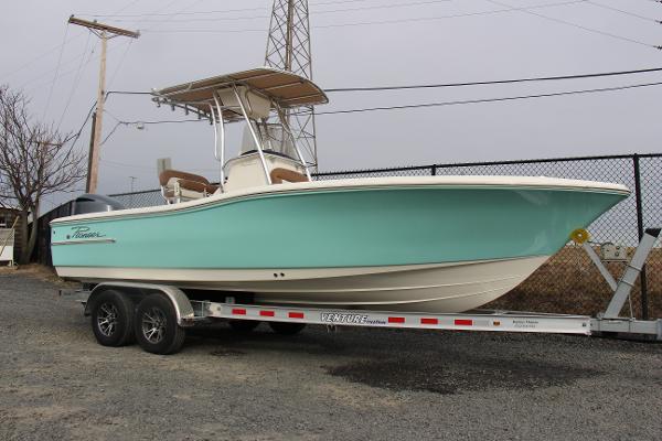 Slide: The Image of 2022 Pioneer 220 Bay Sport boat on trailer, light blue hull, parked outdoors. - 4