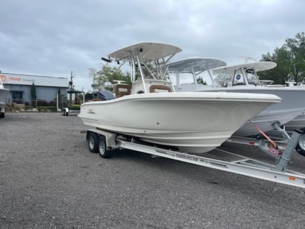 Slide: The Image of 2024 Pioneer 222 Islander boat on a trailer in a dealership lot. - 0