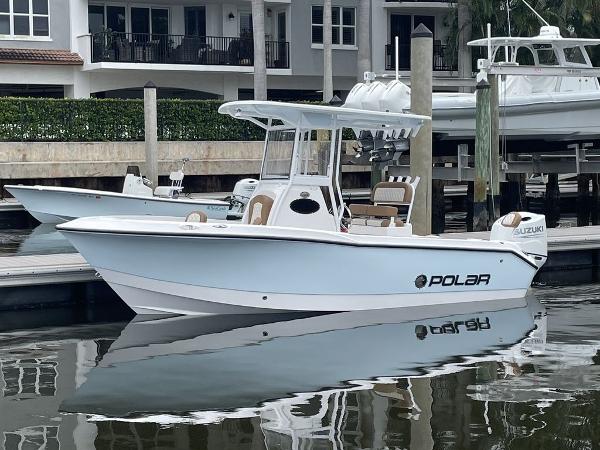 Slide: The Image of 2024 Polar 220 CC boat docked at marina with Suzuki outboard motor. - 1