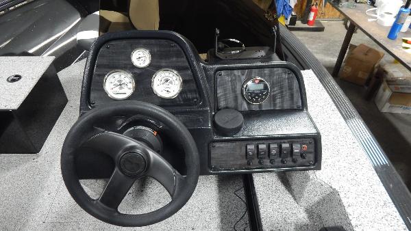 Slide: The Image of 2024 Polar Kraft Outlander 186 SC boat dashboard with steering wheel and gauges. - 26
