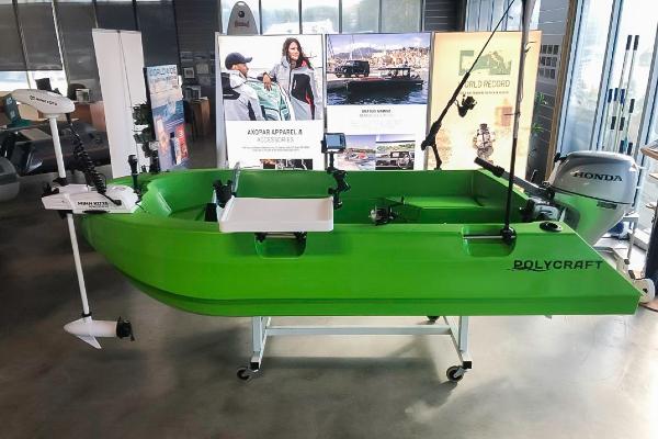 Slide: The Image of Green 2021 Polycraft 300 Tuffy boat displayed indoors with Honda motor and fishing equipment. - 0