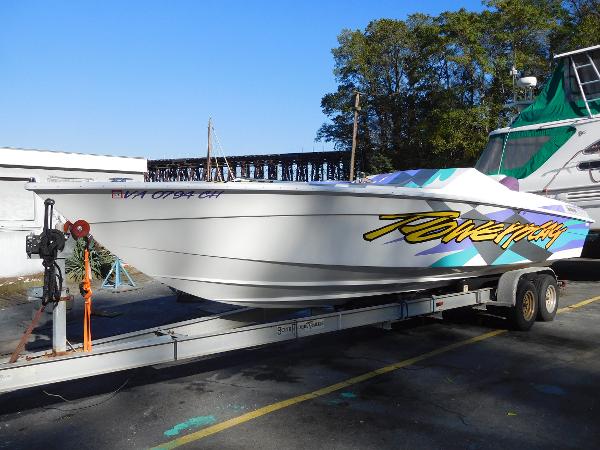 Slide: The Image of 1997 Powerplay Powerboats 28 Sport Deck on trailer, vibrant graphics, parked outdoors. - 1