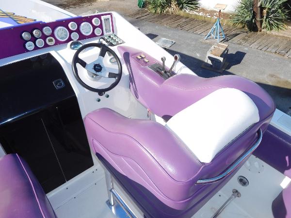 Slide: The Image of 1997 Powerplay Powerboats 28 Sport Deck with purple and white seating, steering wheel, and dashboard. - 16