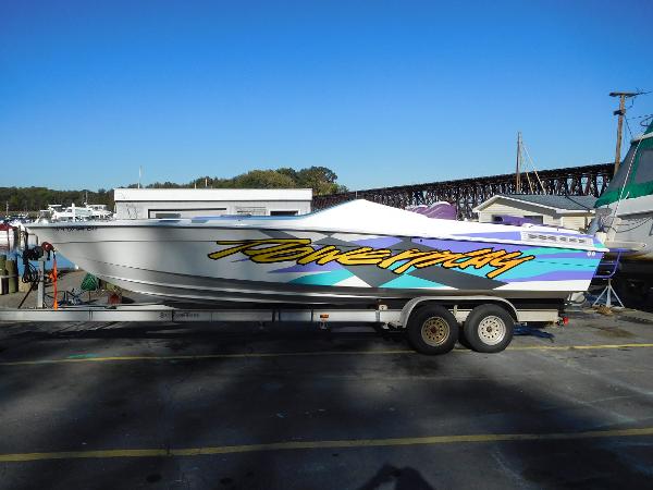Slide: The Image of 1997 Powerplay Powerboats 28 Sport Deck on trailer, vibrant graphics, sunny day. - 2