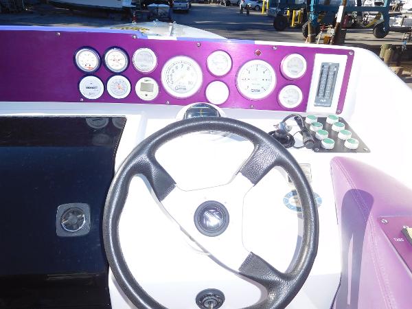 Slide: The Image of 1997 Powerplay Powerboats 28 Sport Deck dashboard with steering wheel and gauges. - 20