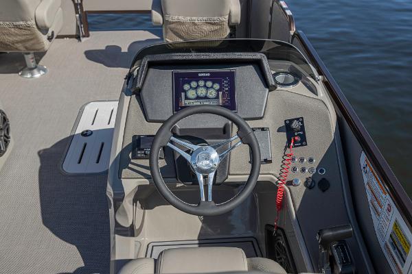 Slide: The Image of 2023 Premier 220 Castaway boat dashboard with steering wheel and control panel. - 10