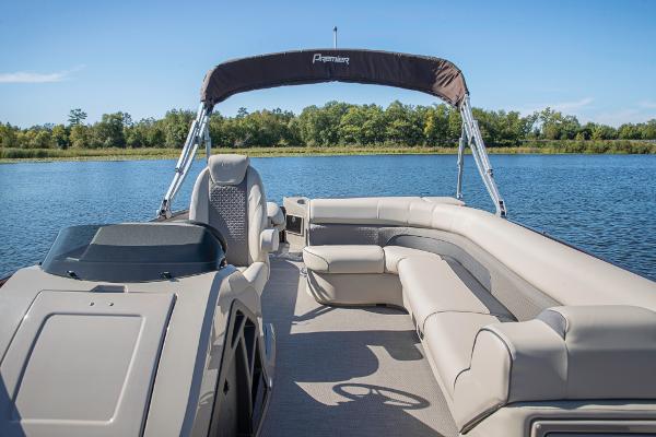 Slide: The Image of 2023 Premier 220 Castaway pontoon boat on a serene lake. - 26