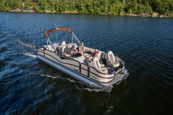 Slide: The Image of 2023 Premier 220 Castaway pontoon boat cruising on a lake with passengers. - 5