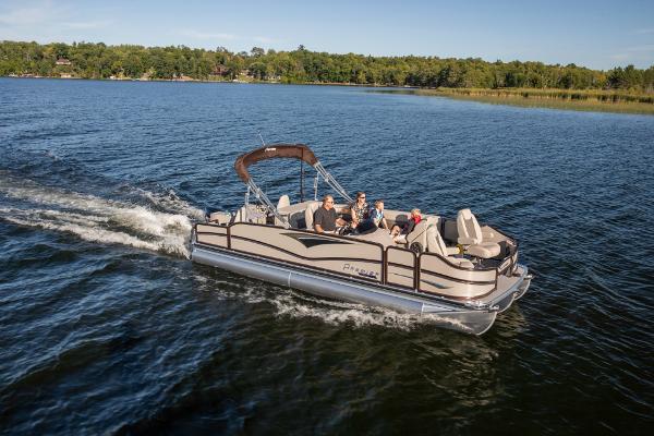 Slide: The Image of 2023 Premier 220 Castaway pontoon boat cruising on a lake with passengers. - 6