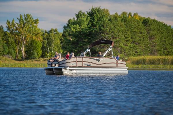 Slide: The Image of 2023 Premier 220 Castaway pontoon boat on a serene lake with lush green trees. - 7