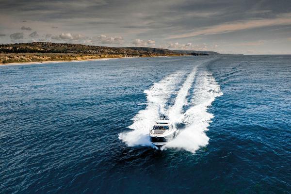Slide: The Image of 2025 Prestige 420S yacht cruising on open sea with scenic coastline backdrop. - 1