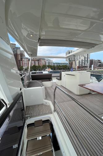 Slide: The Image of Luxurious 2017 Prestige 63 yacht deck with modern seating and cityscape view. - 12
