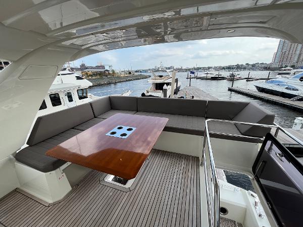 Slide: The Image of Luxurious 2017 Prestige 63 yacht with spacious deck seating and elegant wooden table. - 27