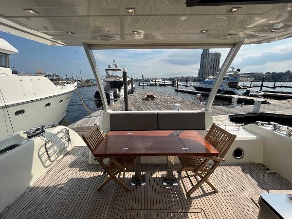 Slide: The Image of Prestige 63 yacht deck with wooden table and chairs, docked at marina, 2017 model. - 28
