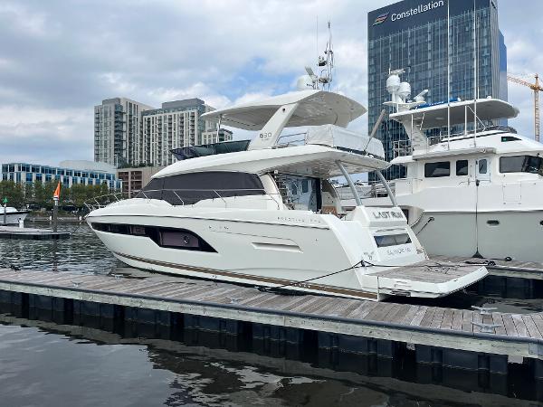 Slide: The Image of Luxury 2017 Prestige 63 yacht docked at marina with cityscape backdrop. - 3