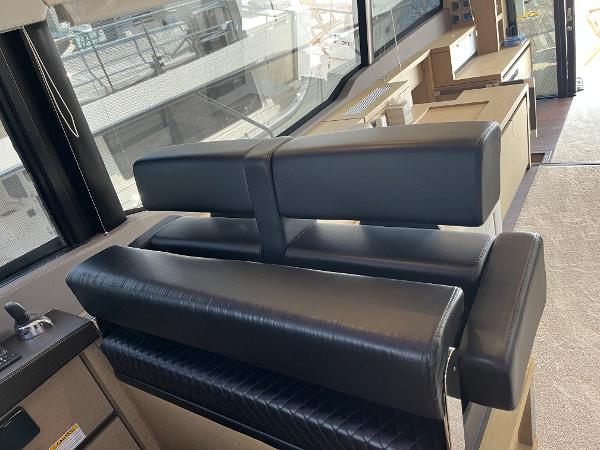 Slide: The Image of Luxurious interior seating on a 2017 Prestige 63 yacht, featuring sleek black leather upholstery. - 45
