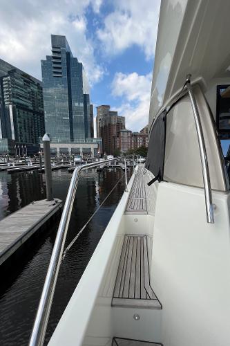 Slide: The Image of Prestige 63 yacht docked in urban marina, 2017 model, with city skyline backdrop. - 9