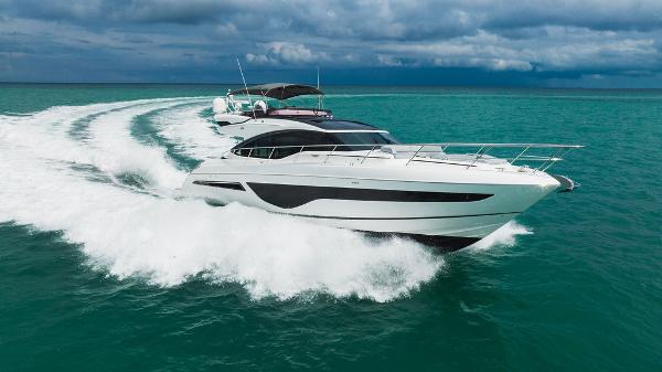 Slide: The Image of Luxury 2022 Princess S66 yacht cruising on turquoise waters under cloudy skies. - 10