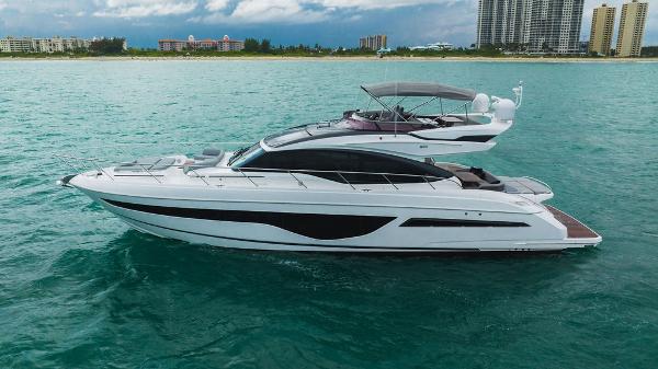 Slide: The Image of Luxury 2022 Princess S66 yacht cruising on turquoise waters near a city skyline. - 29