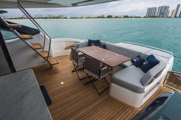 Slide: The Image of Luxurious 2022 Princess S66 yacht deck with seating and dining area, overlooking serene waters. - 42