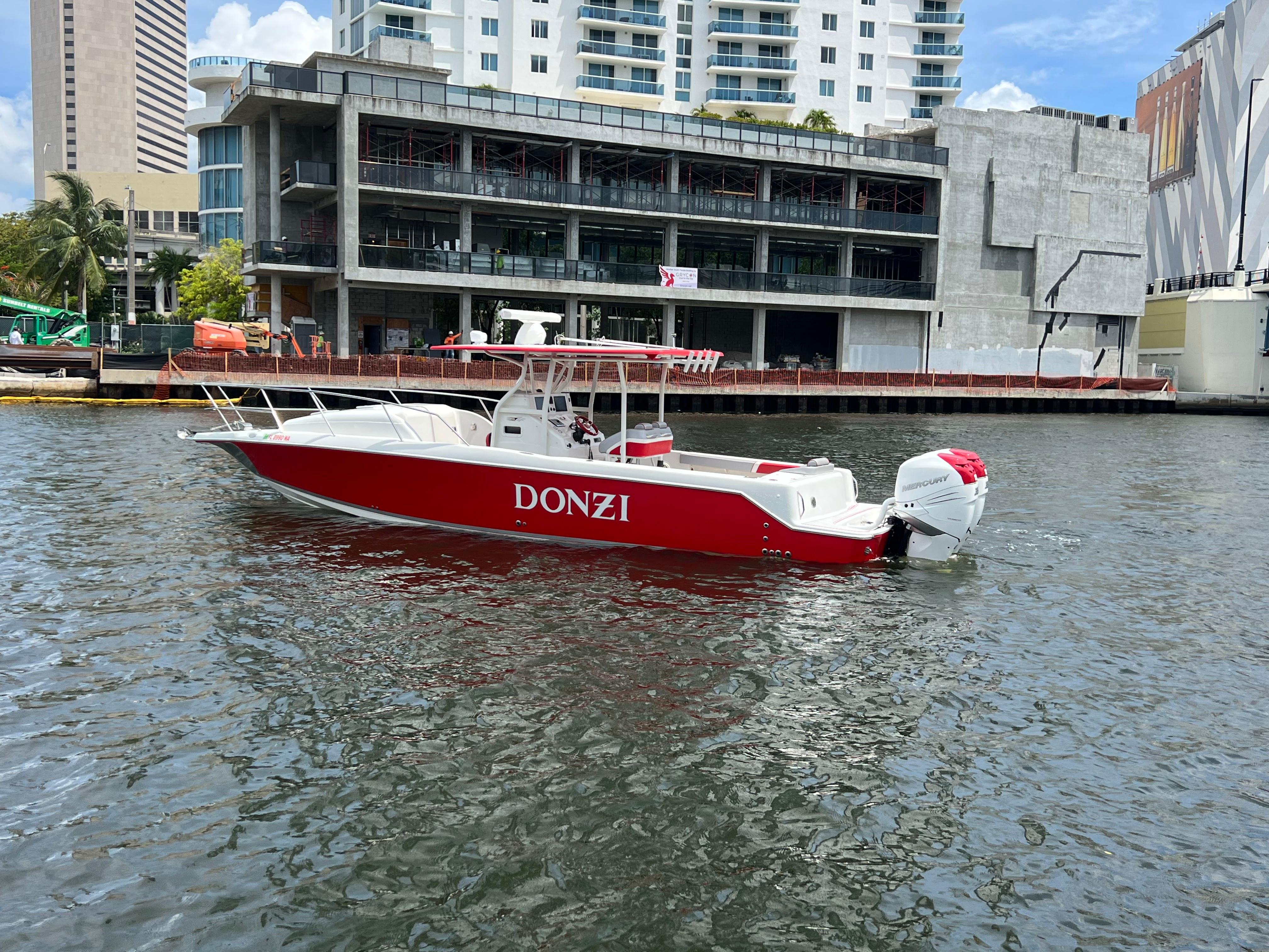 Slide: The Image of Red and white 2016 Pro-Line 3400 Cuddy boat docked near urban buildings. - 1