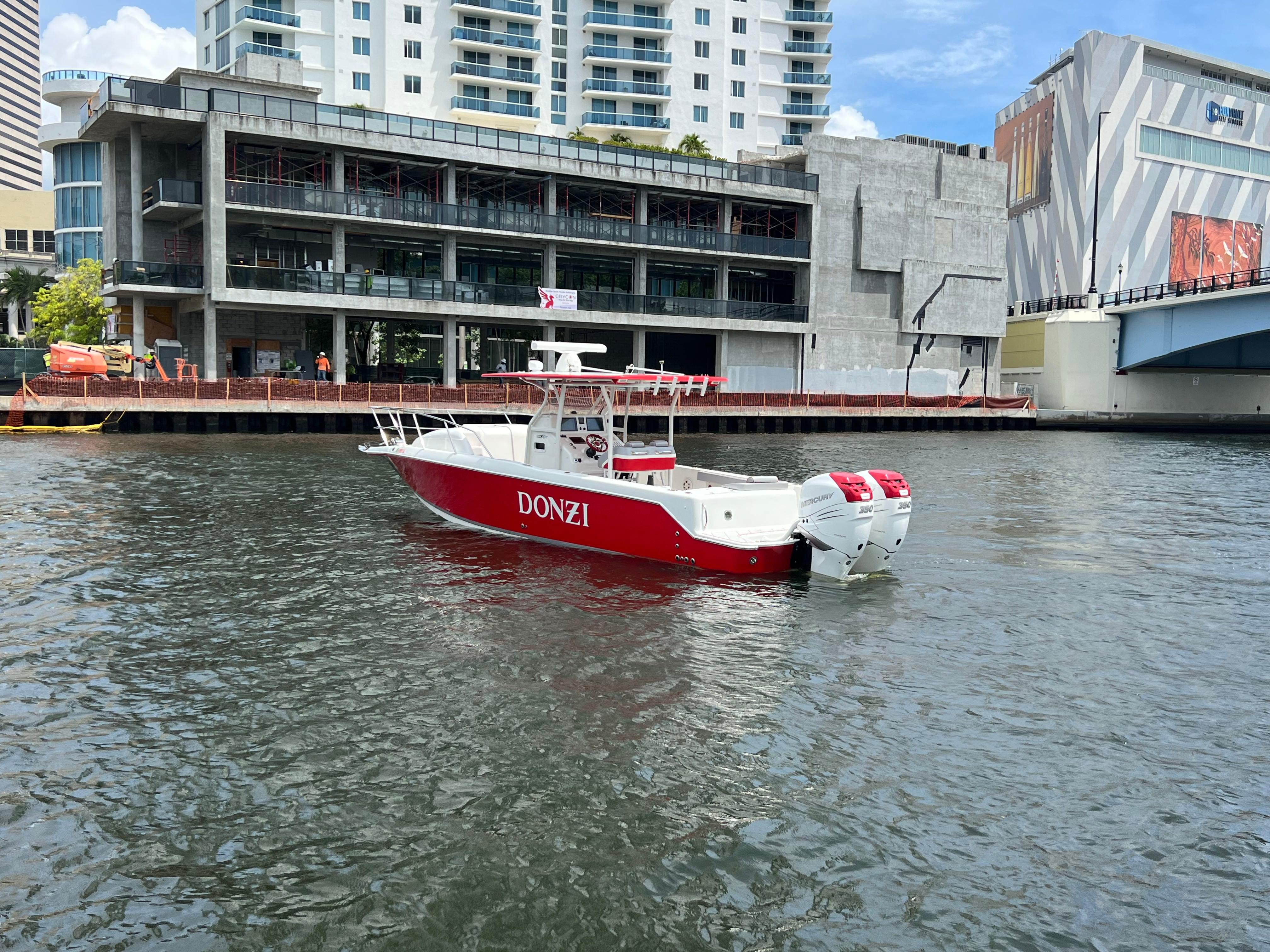 Slide: The Image of Red and white 2016 Pro-Line 3400 Cuddy boat on urban waterway. - 2