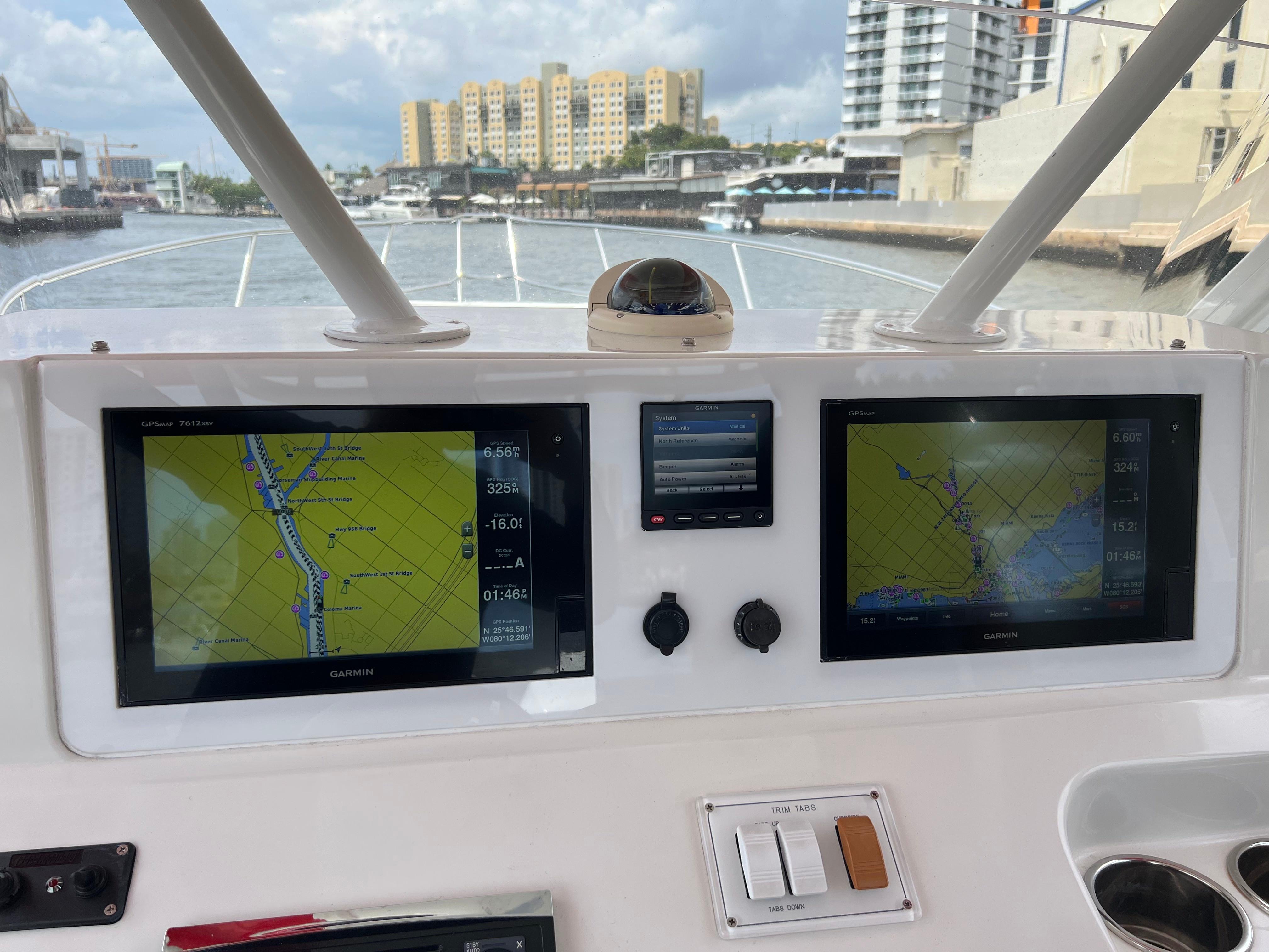 Slide: The Image of Pro-Line 3400 Cuddy 2016 boat dashboard with dual Garmin GPS displays and cityscape view. - 20