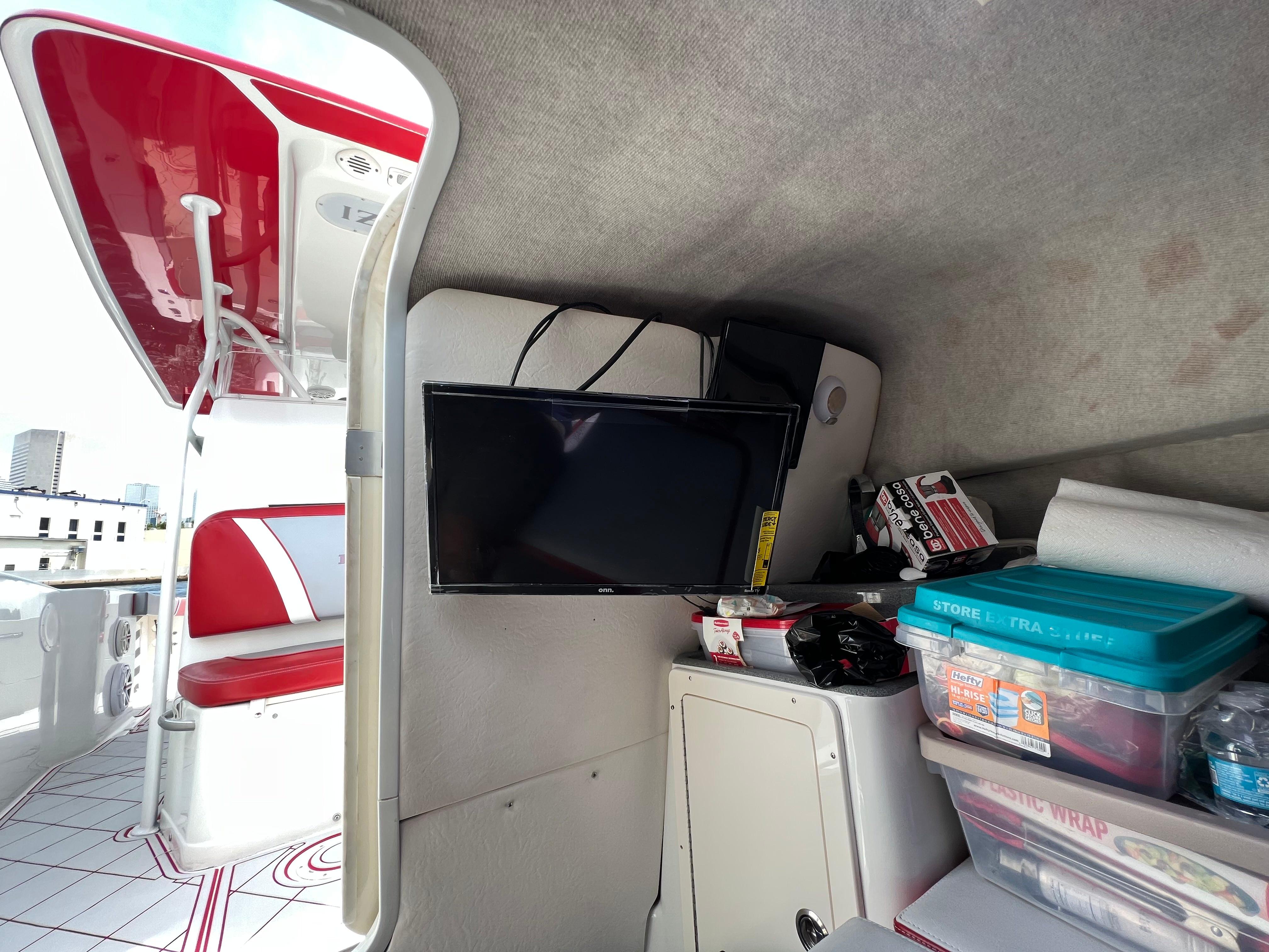 Slide: The Image of Interior of a 2016 Pro-Line 3400 Cuddy boat with TV and storage containers. - 24