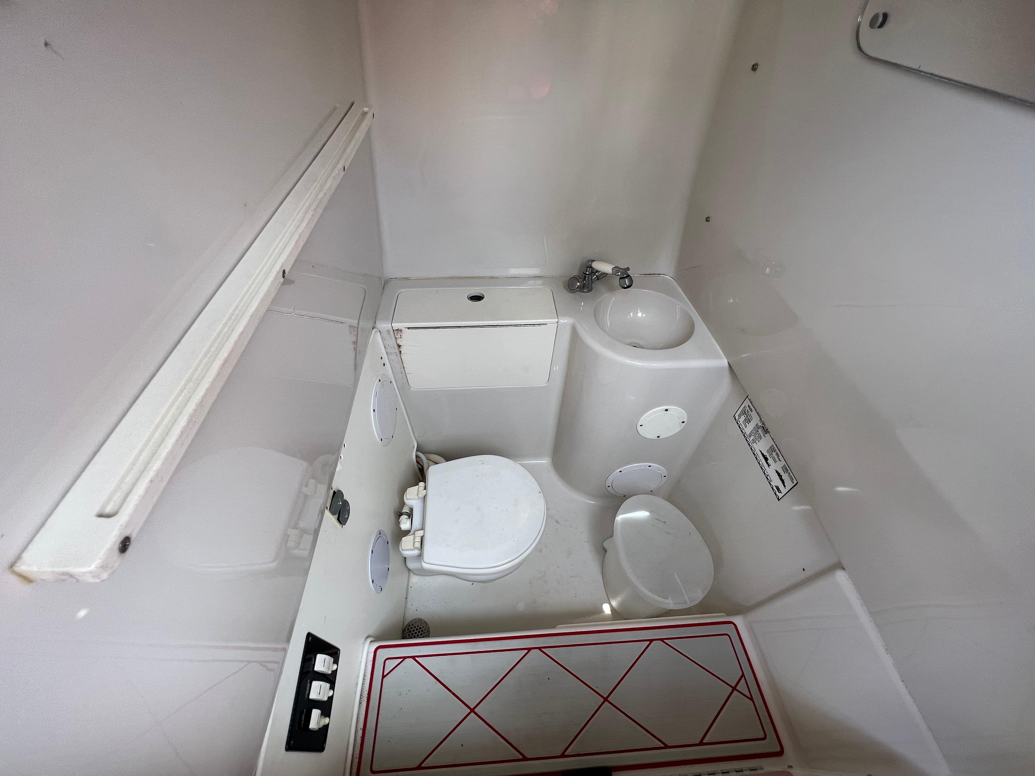 Slide: The Image of 2016 Pro-Line 3400 Cuddy boat bathroom with toilet and sink. - 26