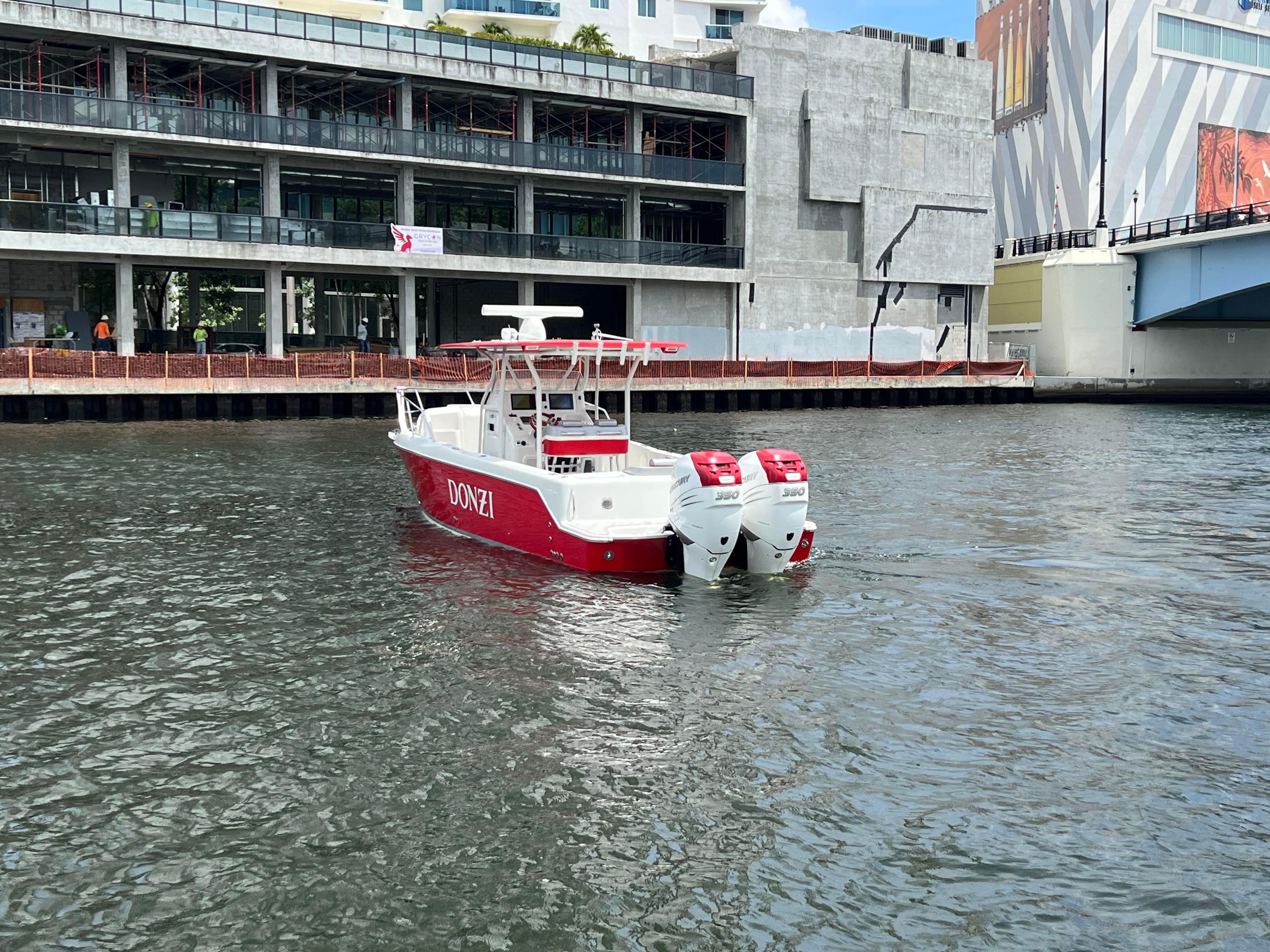 Slide: The Image of 2016 Pro-Line 3400 Cuddy boat with twin outboard engines on urban waterway. - 3