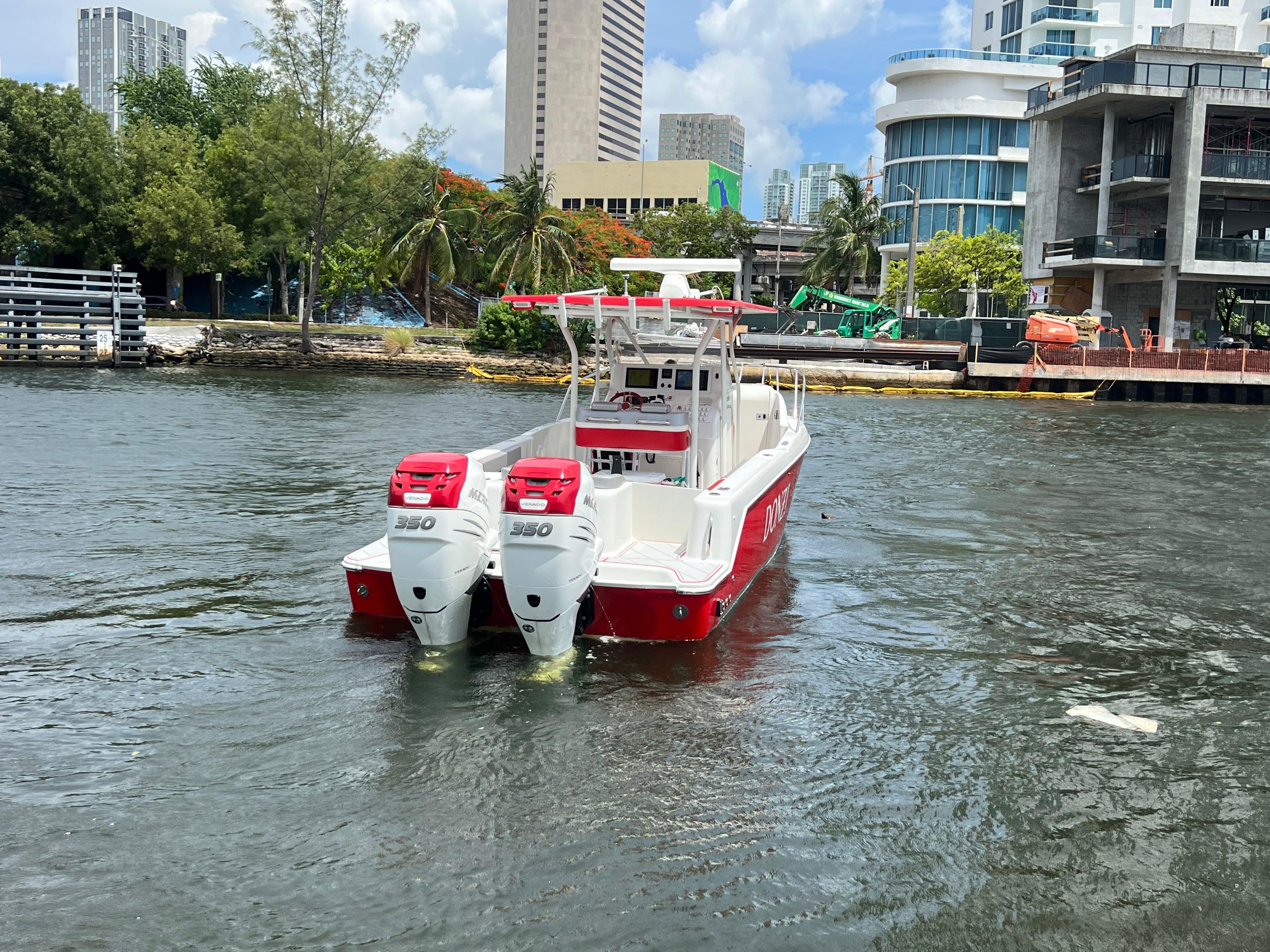 Slide: The Image of 2016 Pro-Line 3400 Cuddy boat with twin 350 HP engines on urban waterway. - 7