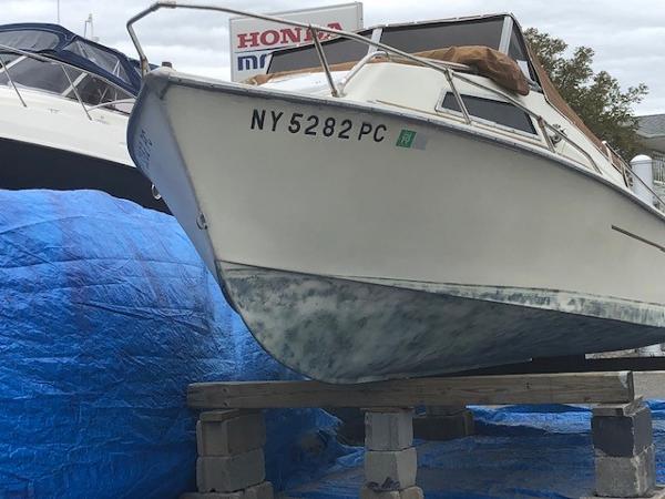 Slide: The Image of 1979 Pro-Line Pro-20 Cuddy boat on blocks, registration NY5282PC, blue tarp underneath. - 1