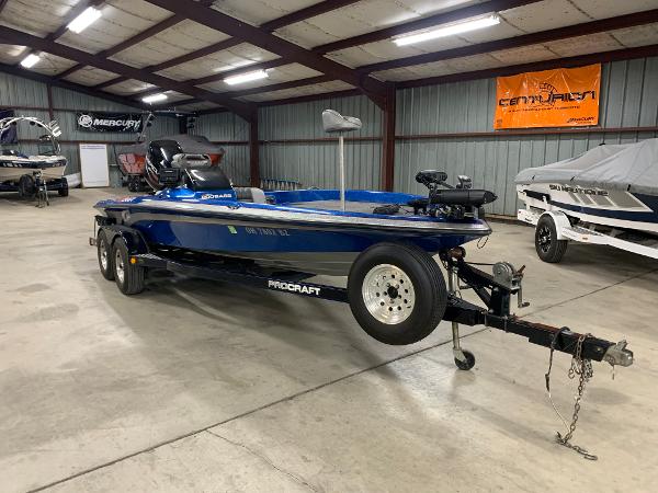 Slide: The Image of 1998 ProCraft 200 Bass boat in a garage, blue exterior, on a trailer. - 1