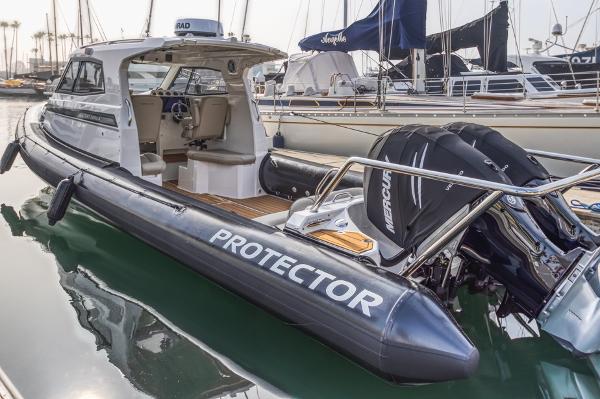 Slide: The Image of 2020 Protector 330 Targa boat docked, featuring dual Mercury engines and sleek design. - 1