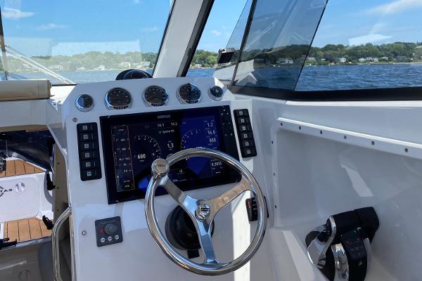 Slide: The Image of 2020 Protector 330 Targa boat cockpit with modern navigation controls and scenic water view. - 26