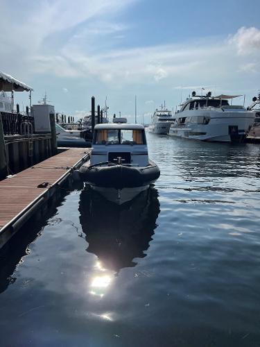 Slide: The Image of 2020 Protector 330 Targa docked at marina with yachts in background. - 8