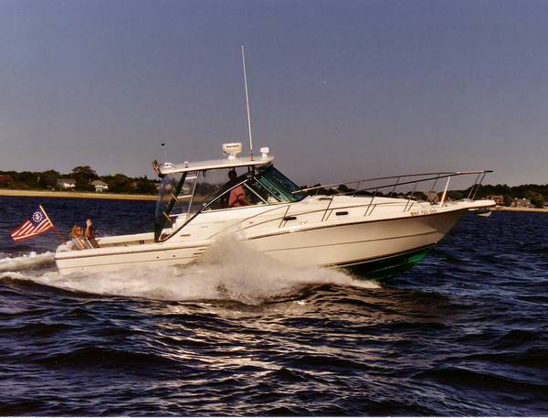 Slide: The Image of 2002 Pursuit 3000 Express boat cruising on open water with American flag. - 1