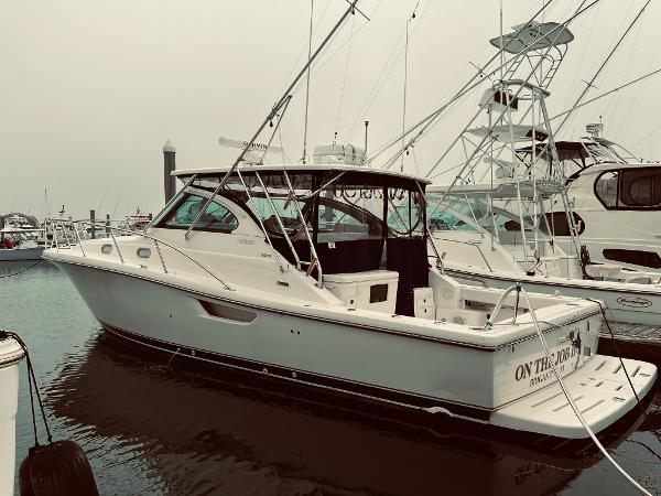 Slide: The Image of 2002 Pursuit 3800 Express boat docked at a marina. - 0