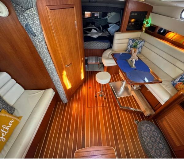 Slide: The Image of Interior of a 2002 Pursuit 3800 Express boat with wooden flooring and cozy seating. - 11