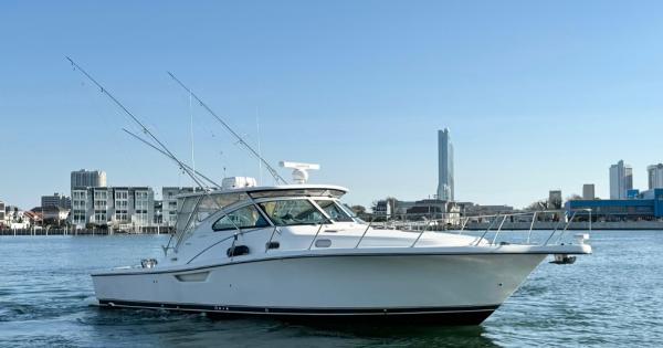 Slide: The Image of 2002 Pursuit 3800 Express boat cruising in urban waterfront. - 4