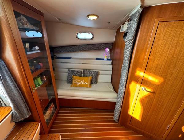 Slide: The Image of Interior cabin of a 2002 Pursuit 3800 Express boat with cozy seating and wooden finishes. - 9
