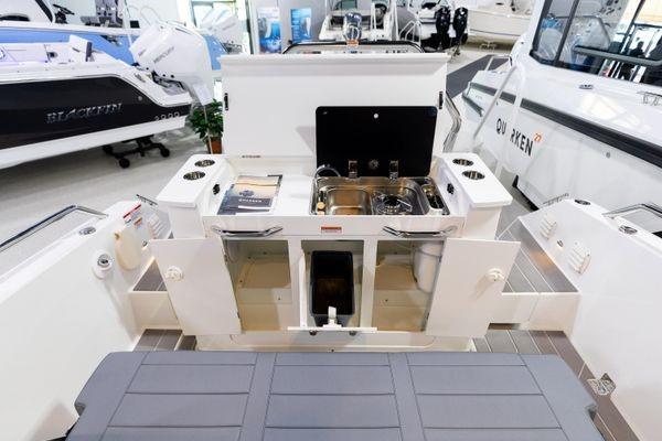 Slide: The Image of 2024 Quarken 27 T-Top V2 boat interior with open storage compartments and sink. - 13