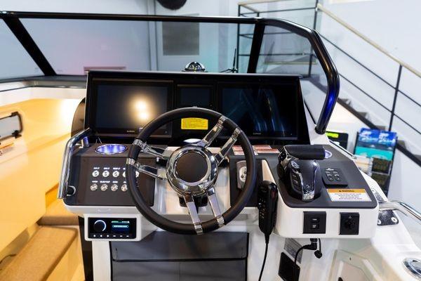 Slide: The Image of 2024 Quarken 27 T-Top V2 boat dashboard with modern controls and steering wheel. - 16