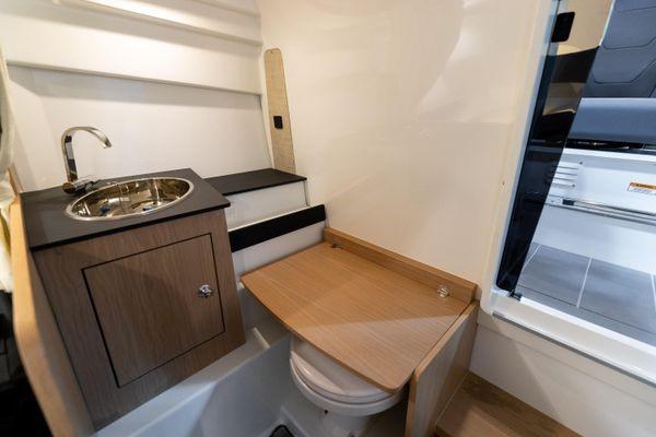 Slide: The Image of 2024 Quarken 27 T-Top V2 boat interior with compact bathroom and sink. - 19